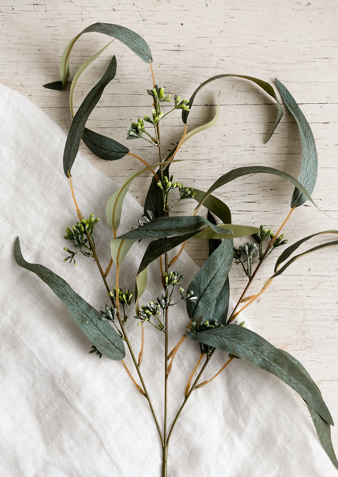 A faux spray of seeded eucalyptus in natural green color.