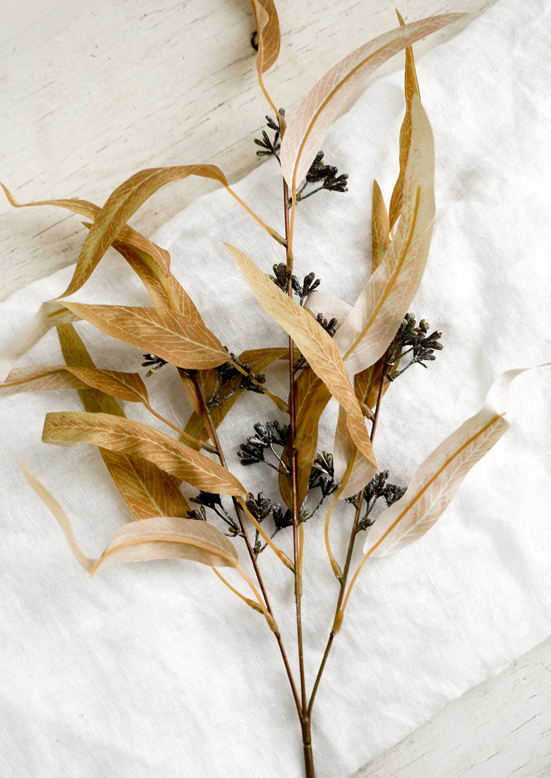 A faux spray of seeded eucalyptus in harvest gold color.