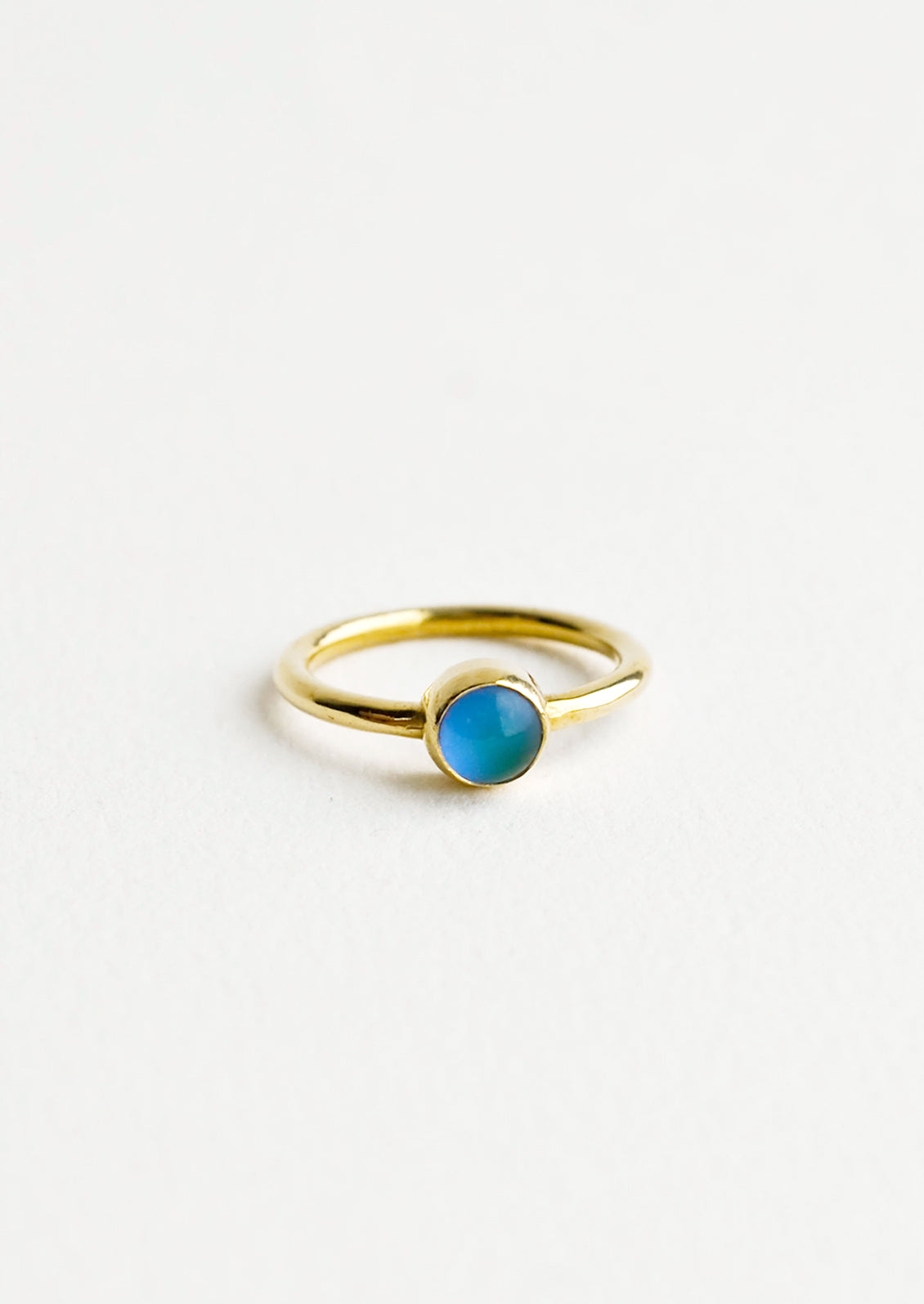 A gold ring with a round blue stone.