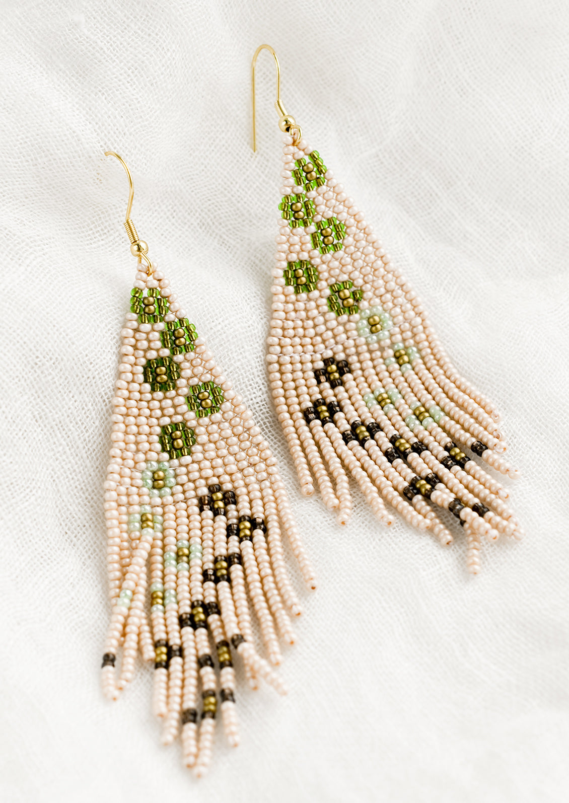 A pair of beaded floral earrings in pale pink.