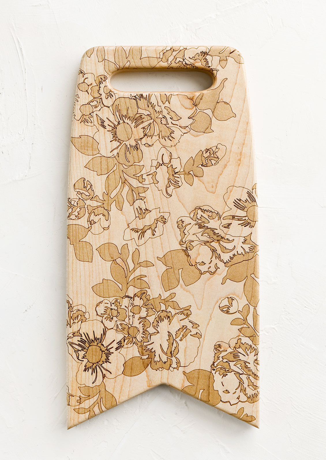 Flag shaped maplewood cutting board with handle cutout, lasercut floral pattern