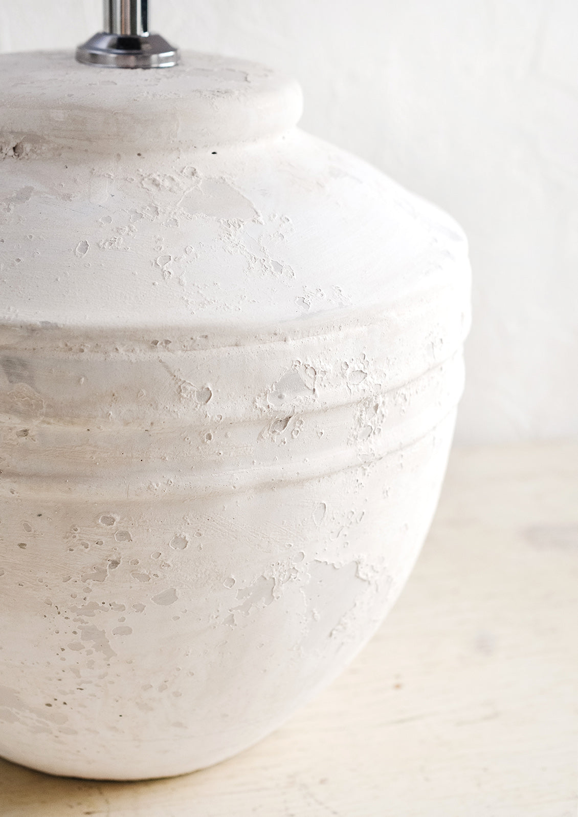 A white distressed concrete table lamp base.