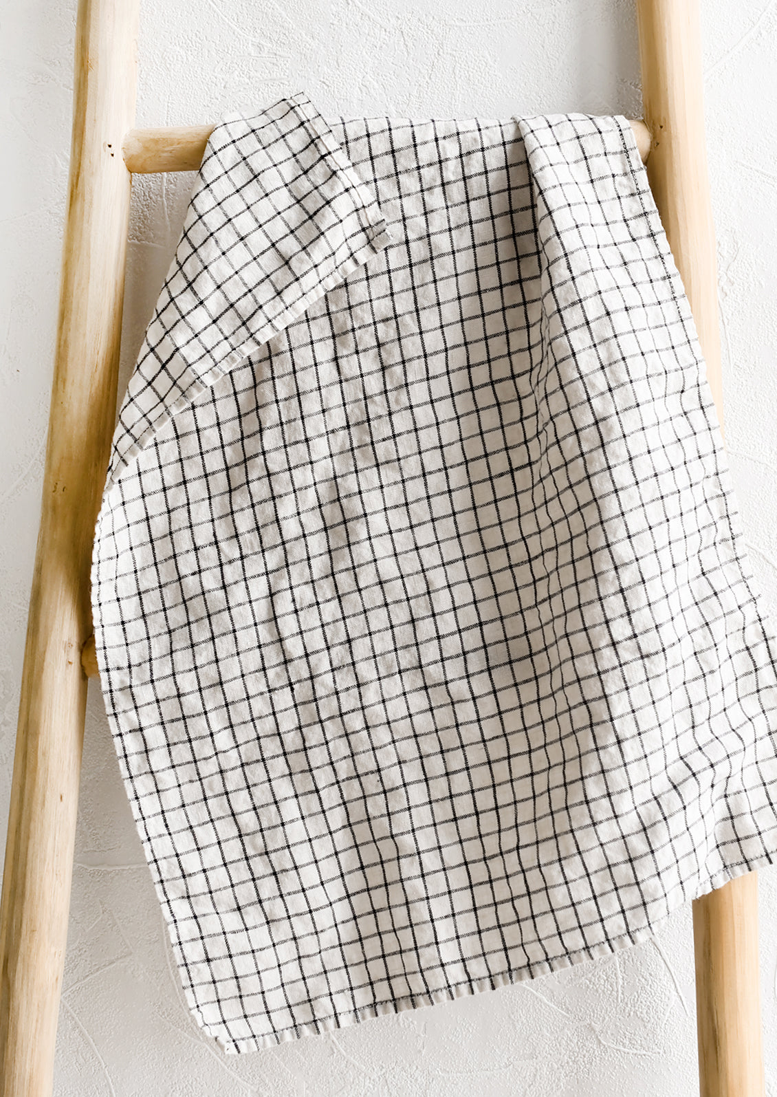 A linen tea towel in black and white windowpane.