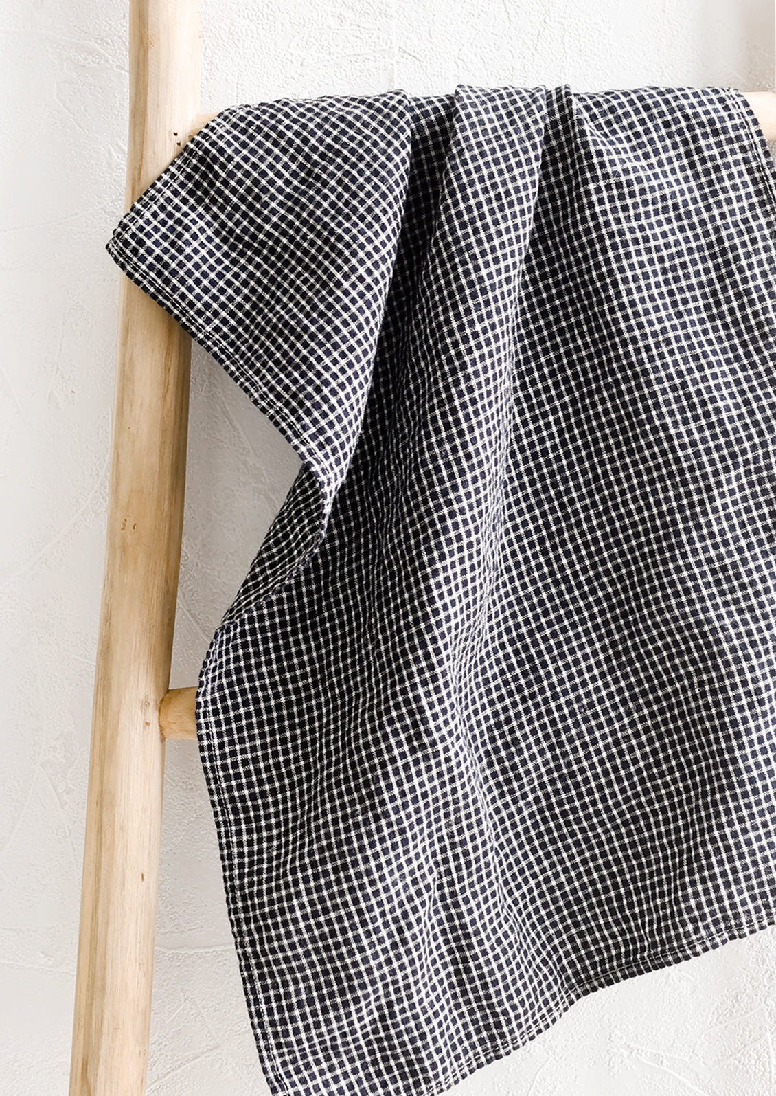 A linen tea towel in black and white microcheck.