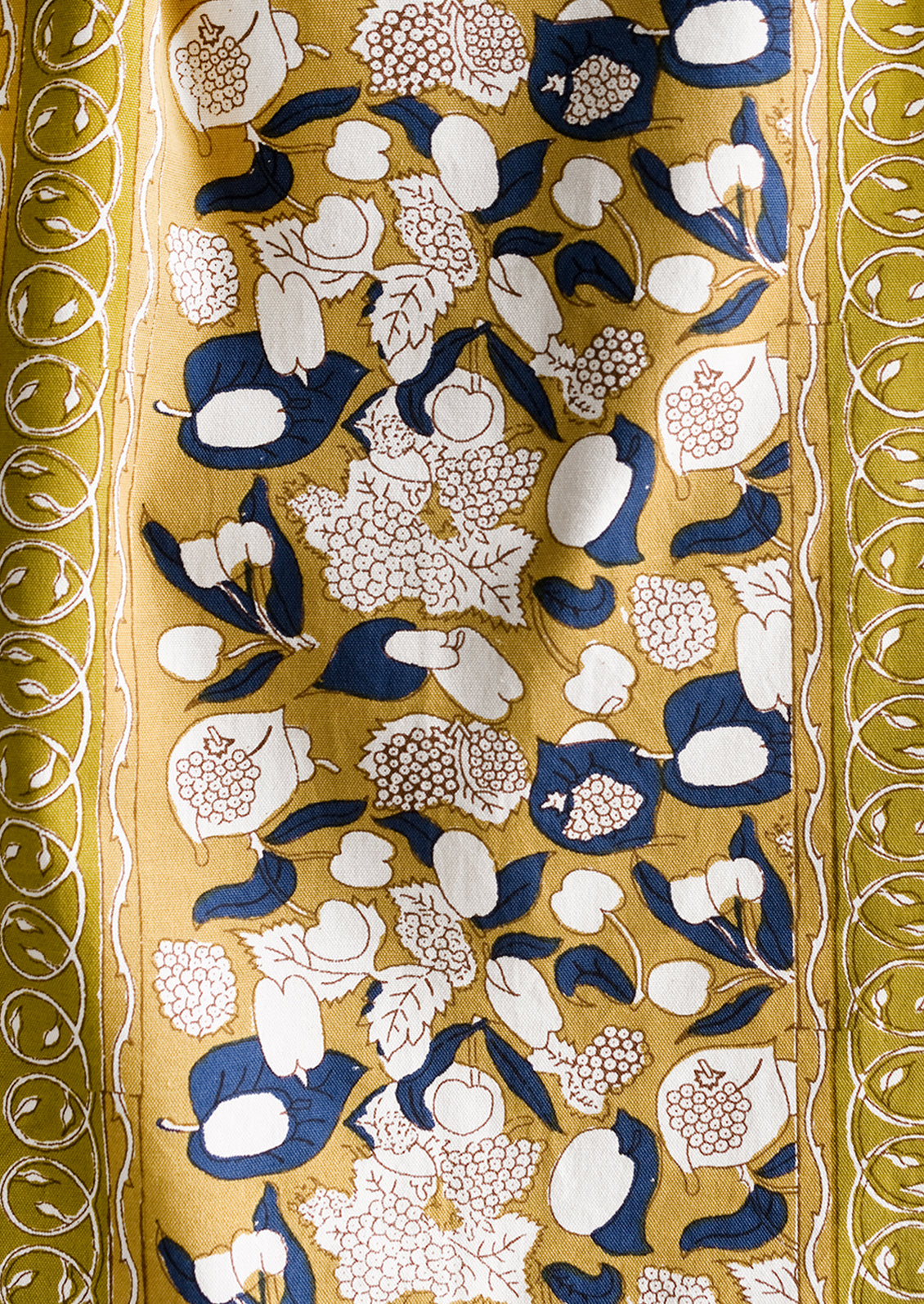 A mustard and navy blue runner with fruit print.