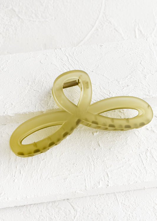 A curvy hair clip with knotted loop design in frosted olive.