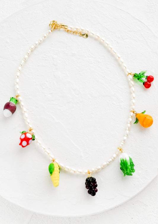 A pearl necklace with glass fruit and veggie charms.