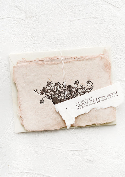 A packaged set of cards made from handmade paper with a letterpress printed image of flowers in a bowl.