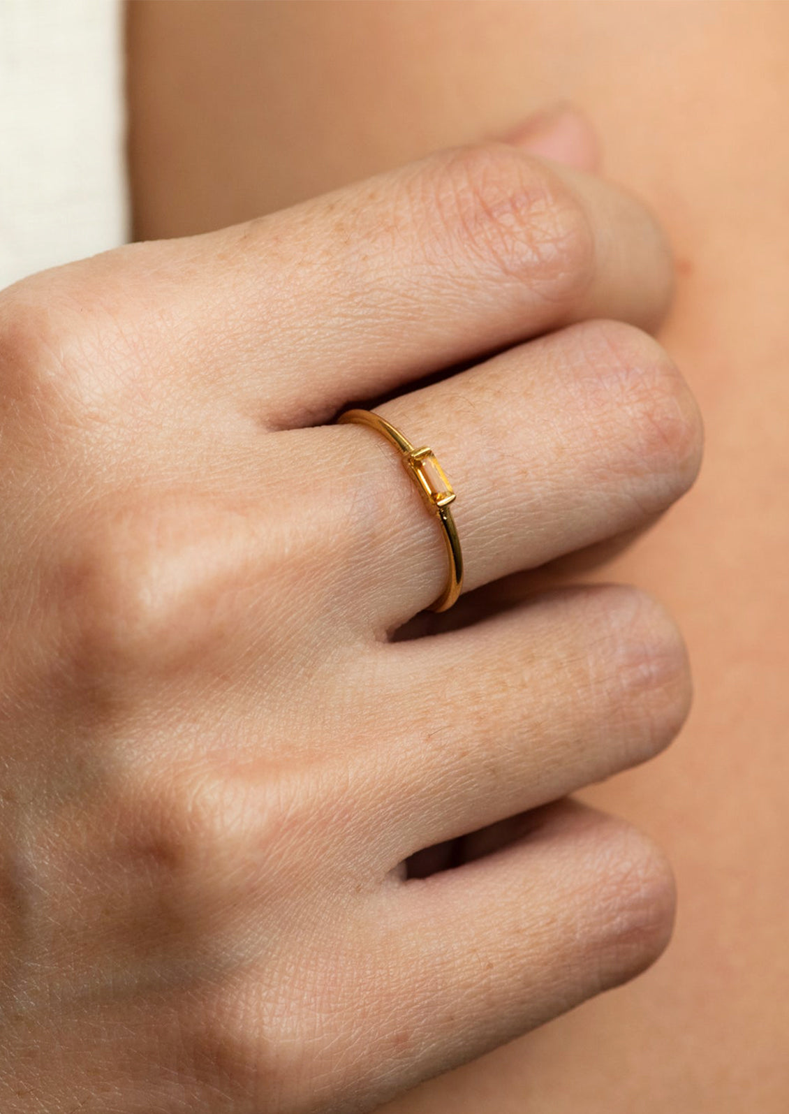 A slim citrine band on a human hand.