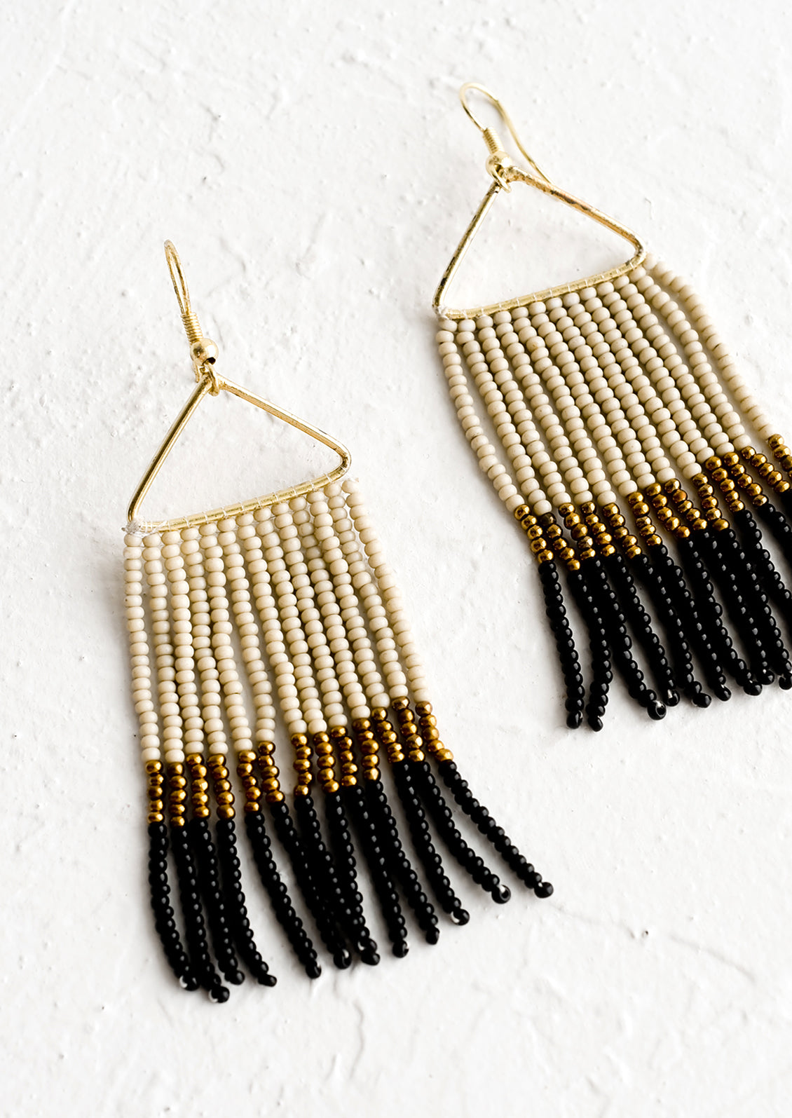 Beaded earrings with triangular metal frame and fringed beads below in colorblock pattern.