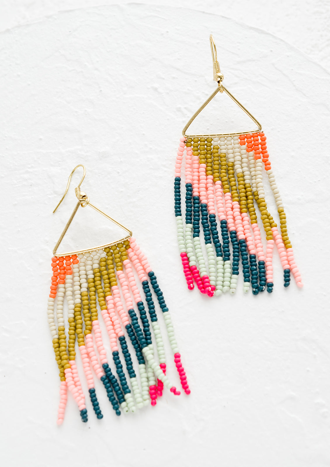 A pair of statement earrings with triangle metal top and fringe beads below.