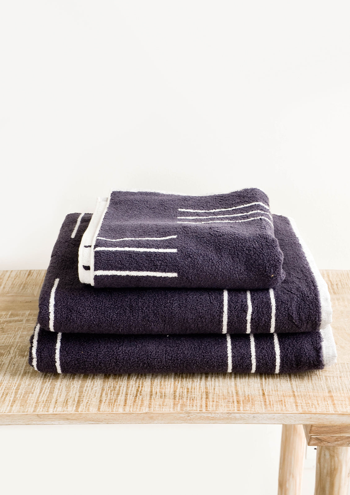 Set of terrycloth towels in dark grey with modern white line print