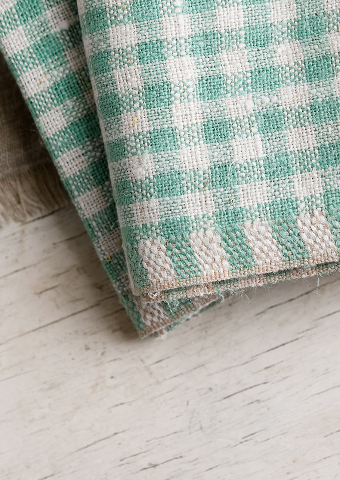 Beige trim stitching on spearmint gingham napkins.