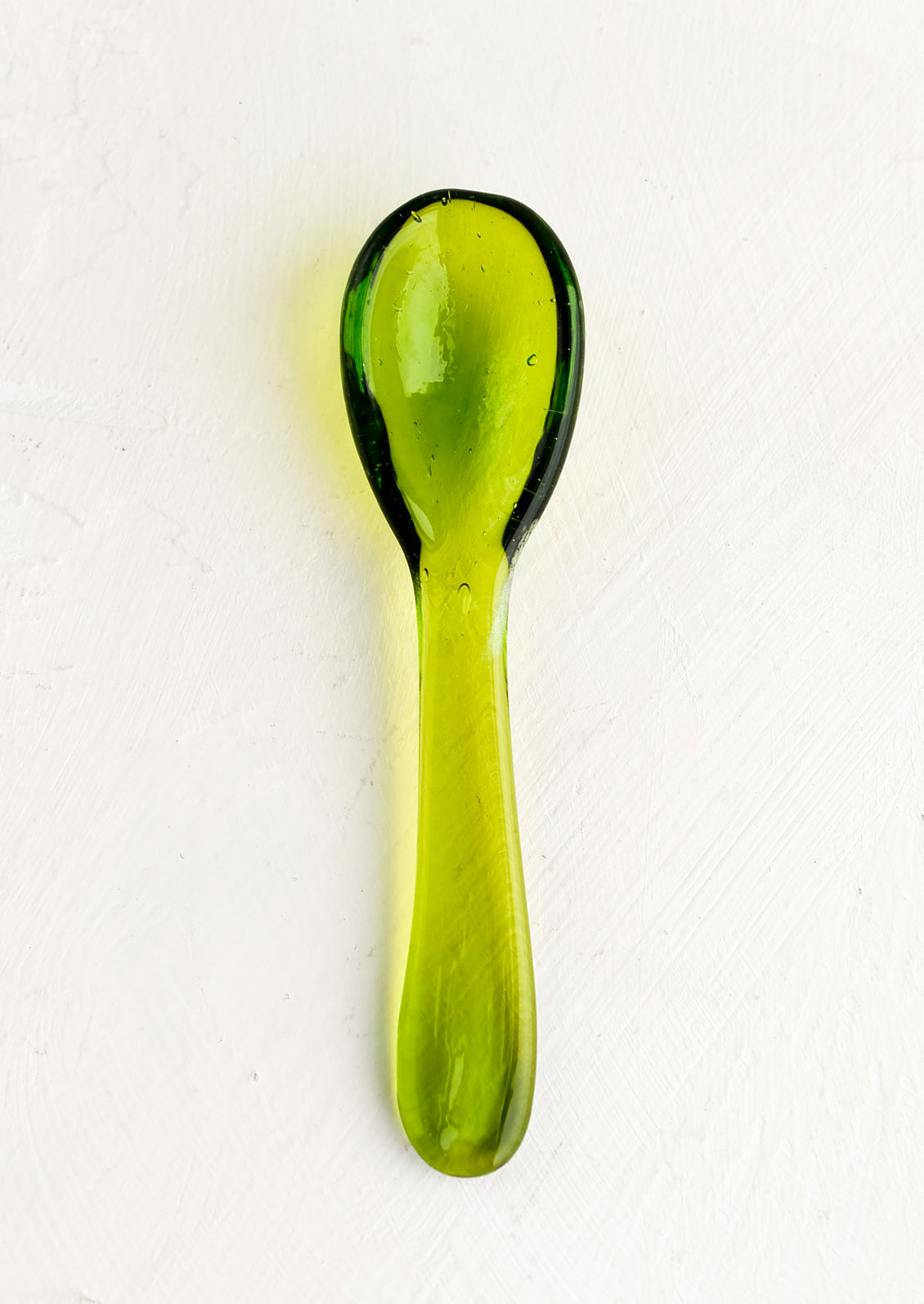 A glass spoon in fern green.