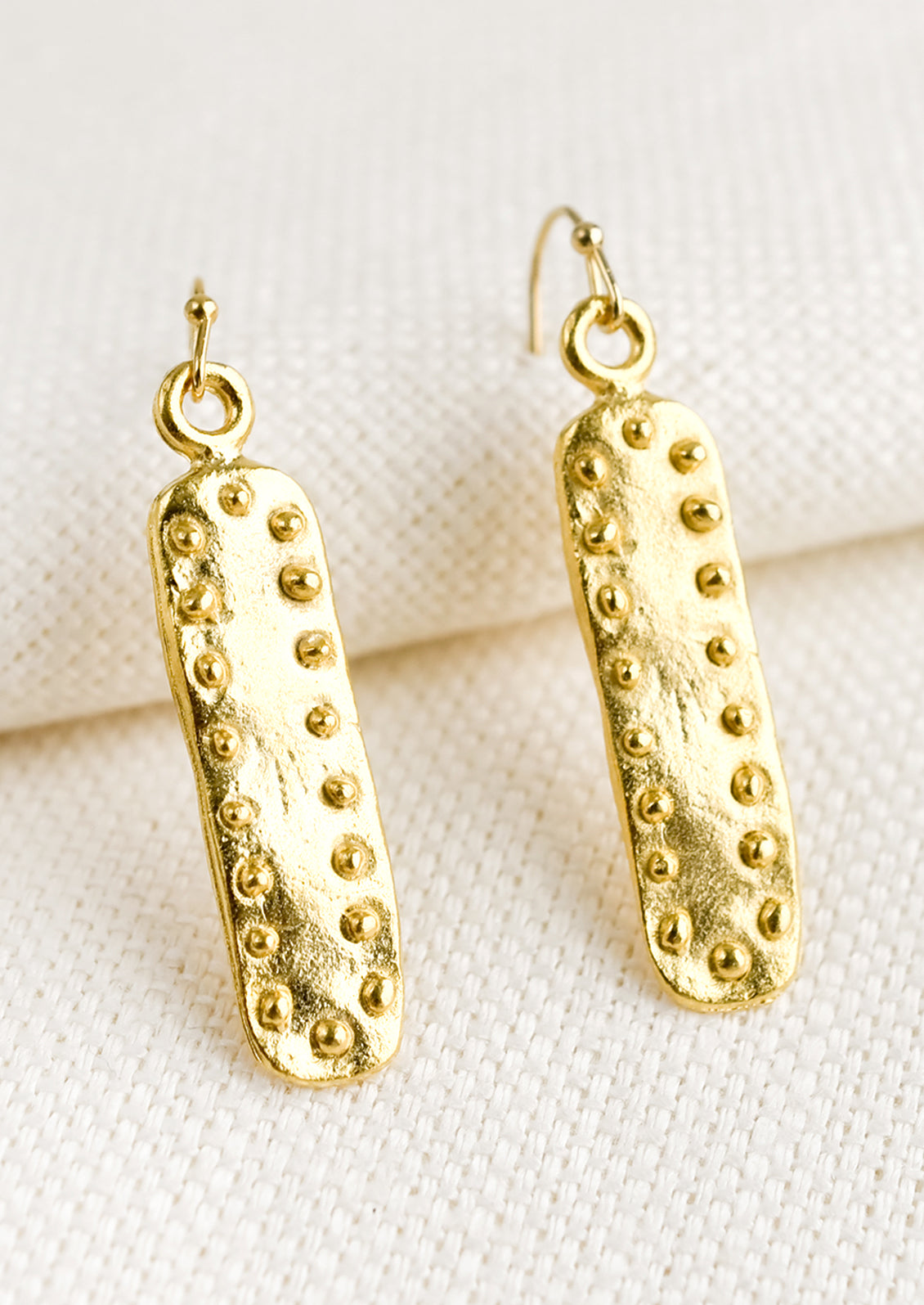 A pair of short bar shaped earrings with raised dot border.