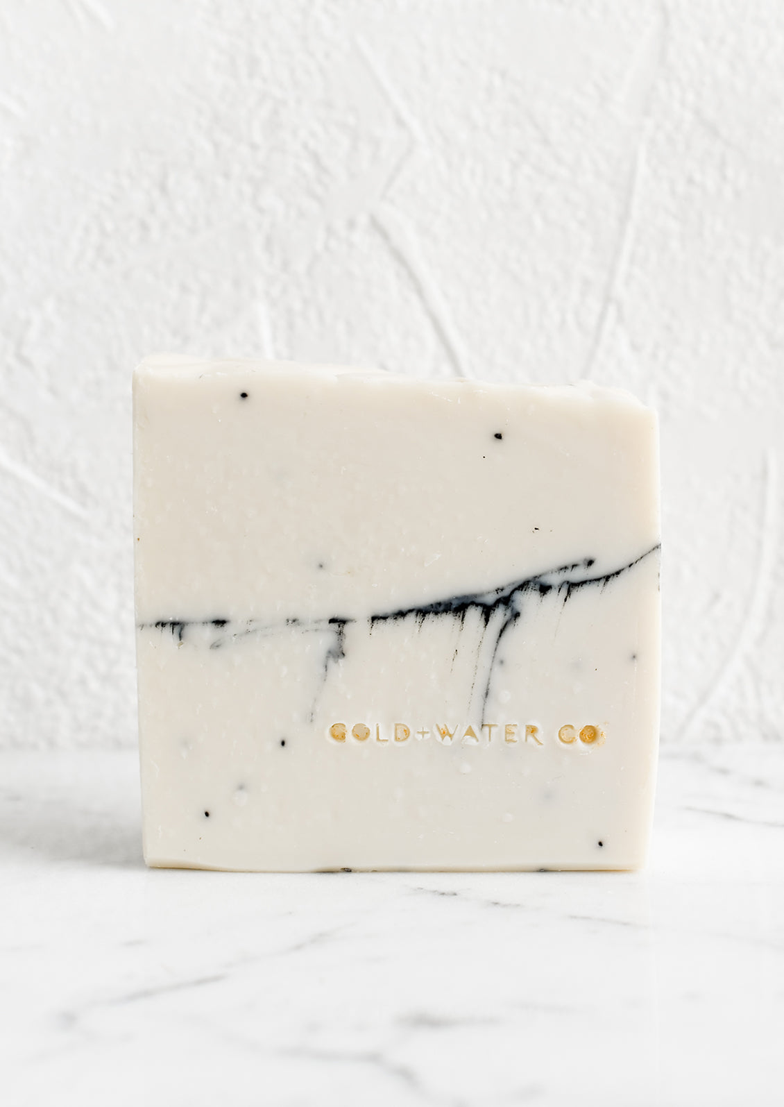 A white bar of soap with brand stamp at corner.