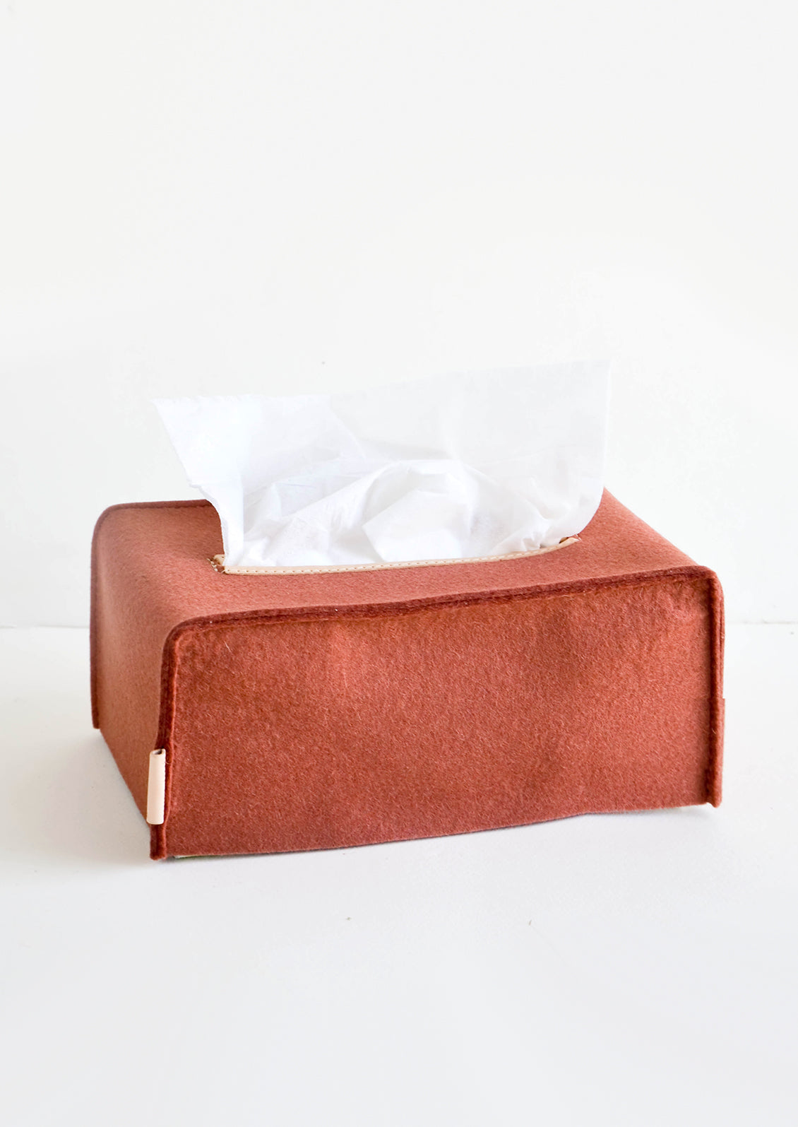 Rectangular-shaped tissue box cover made from felted wool in brick red color with leather accents