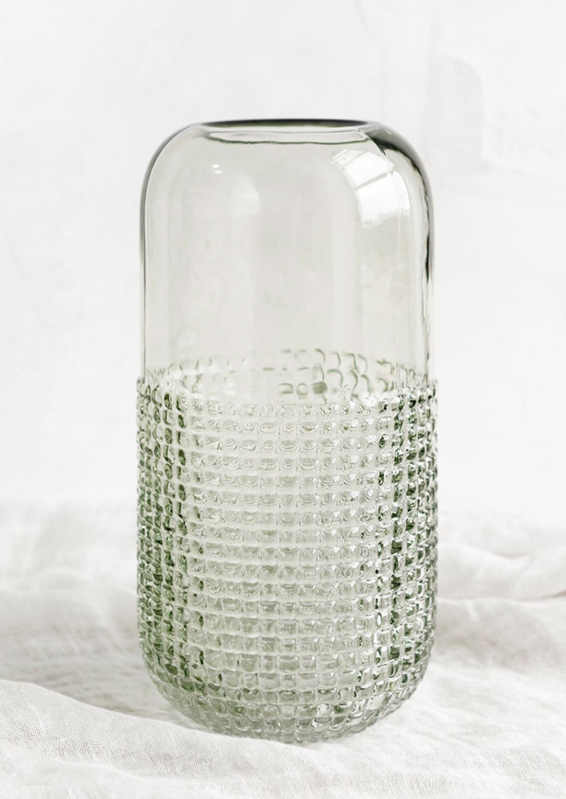 A glass vase with pyramid grid texture on lower half.