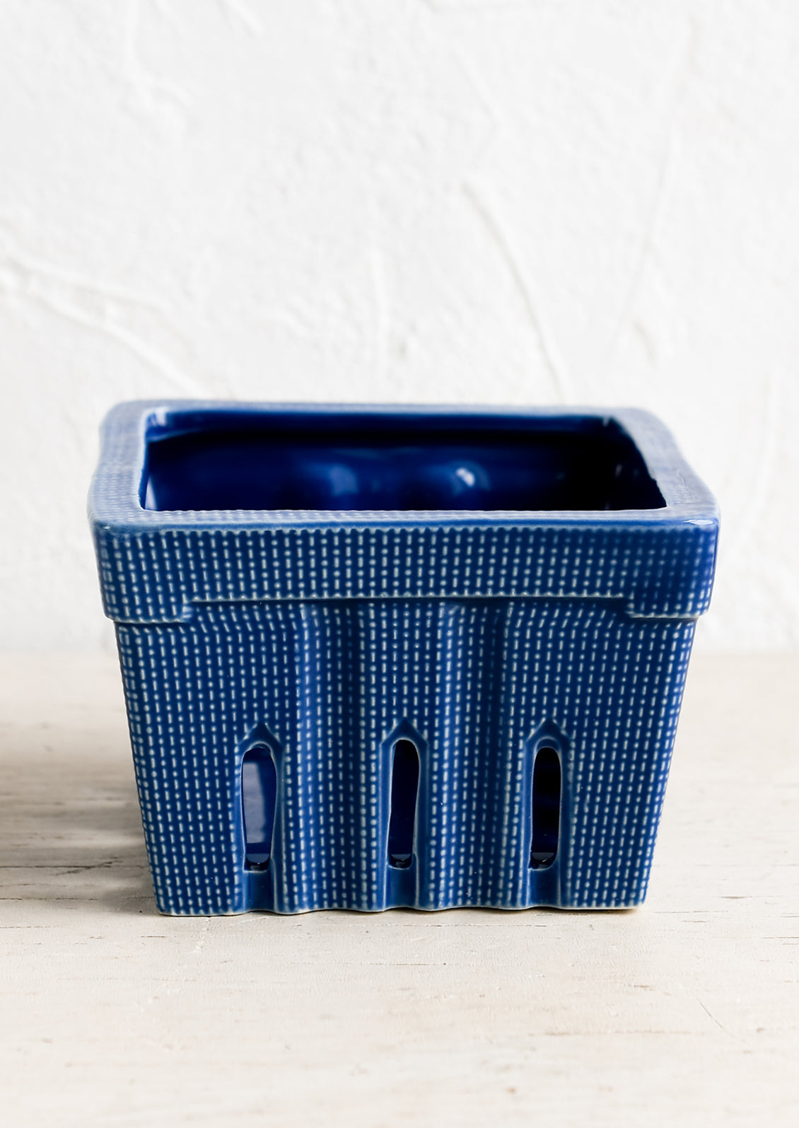 A ceramic berry basket in cobalt blue.