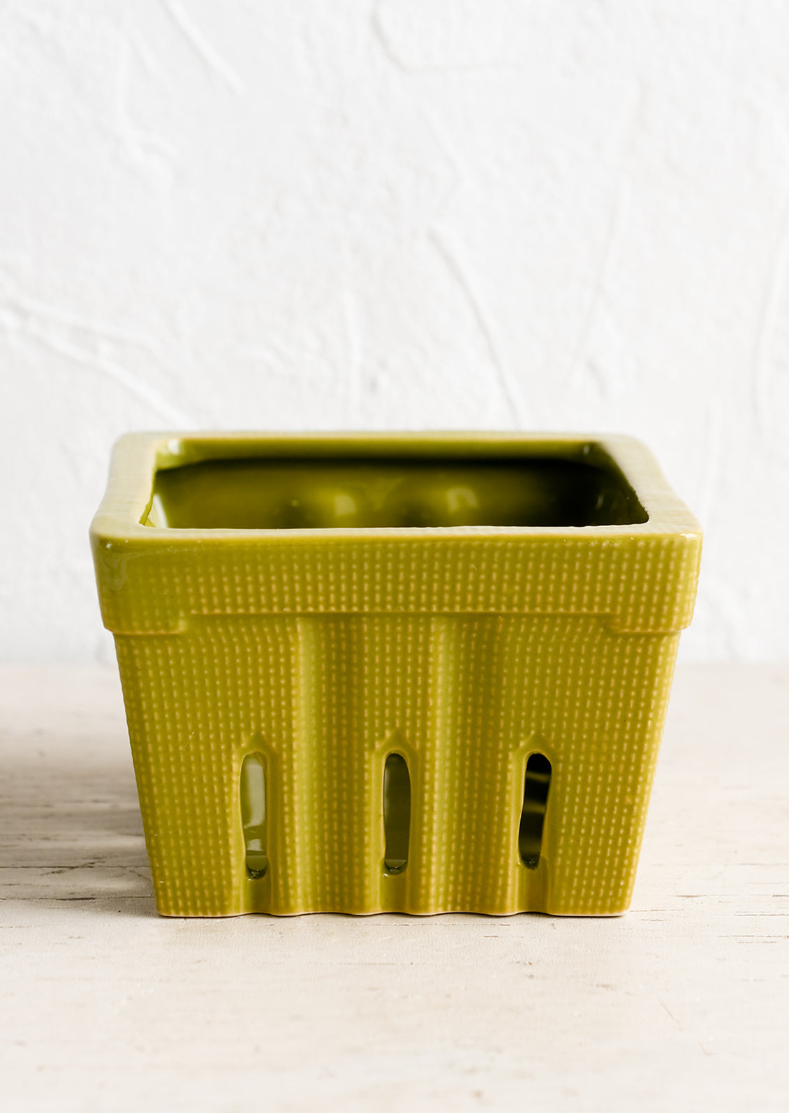 A ceramic berry basket in moss green.