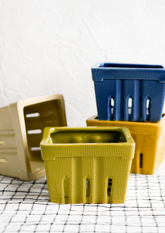 Ceramic berry baskets in blues, greens and yellows.
