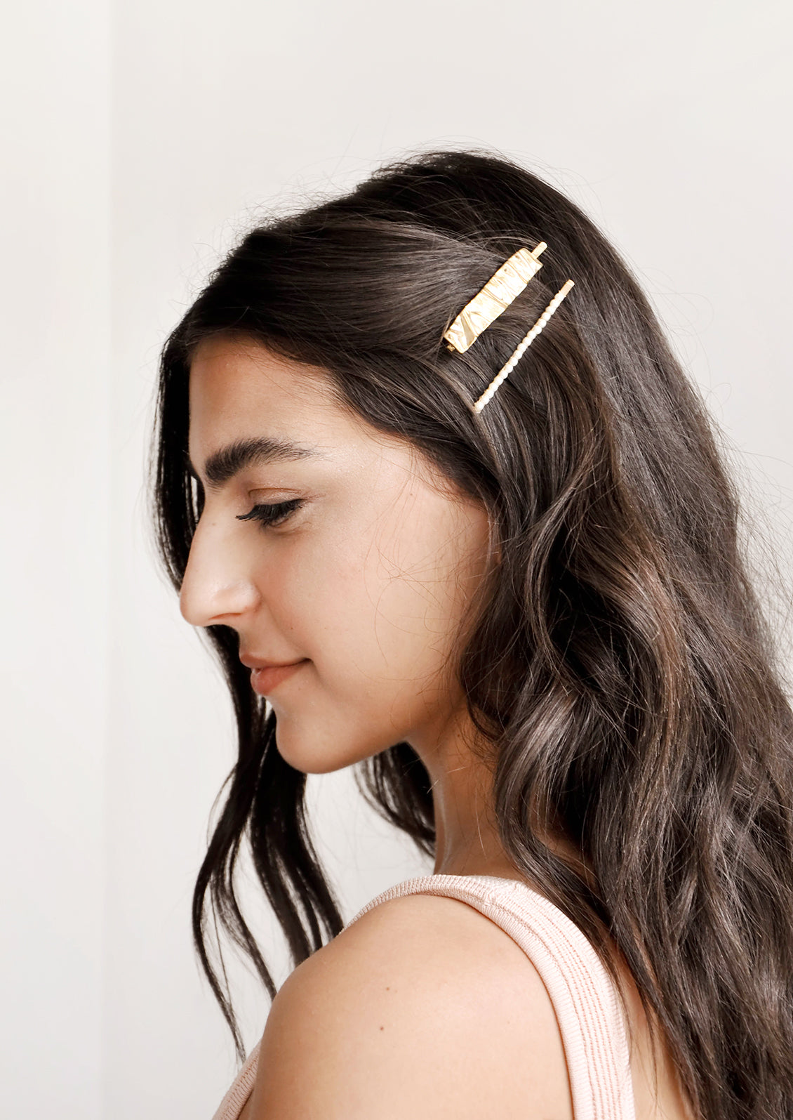 Two gold rectangular hair clips shown on model with brown hair