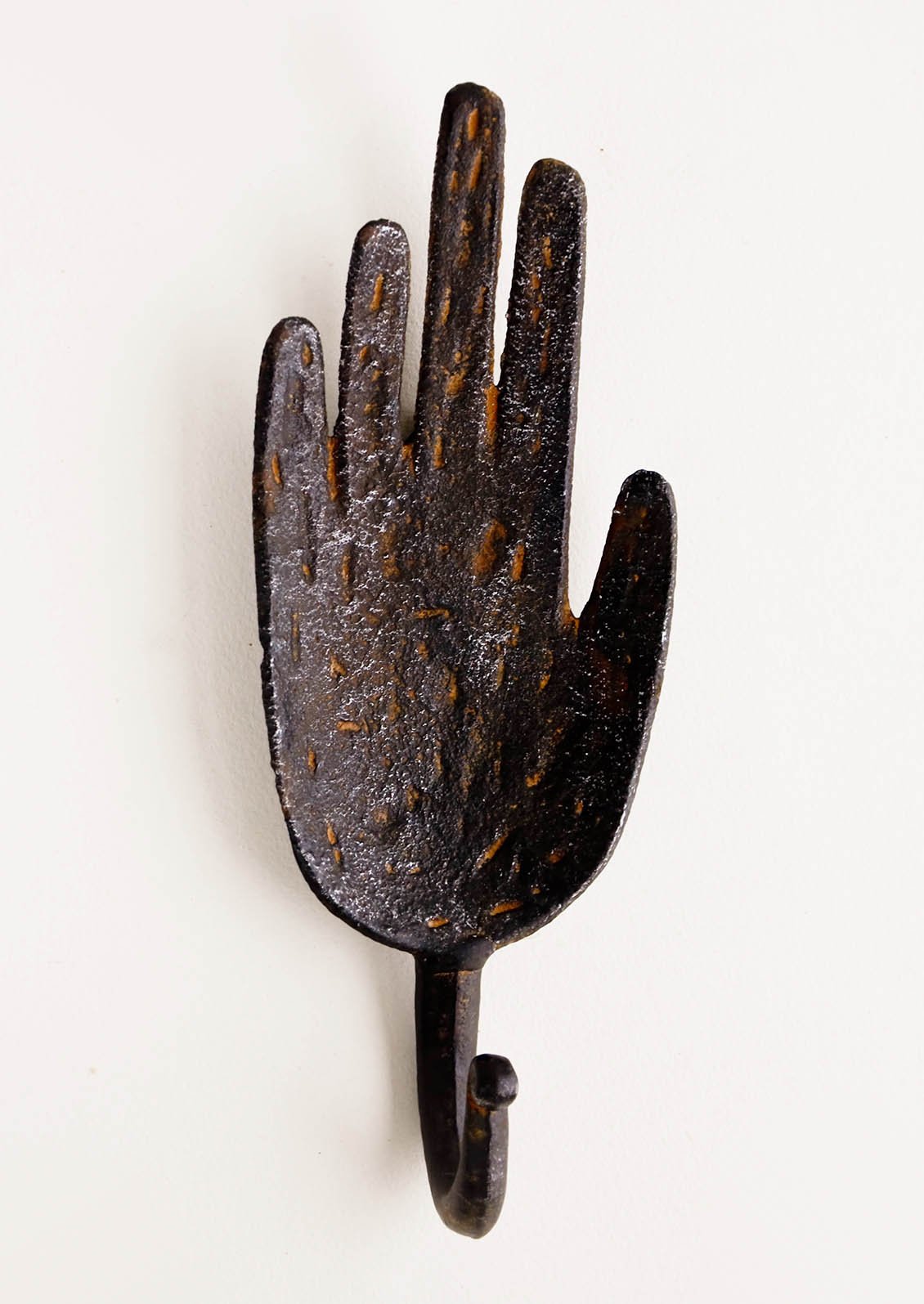 Wall hook in the shape of a hand, made in dark distressed metal