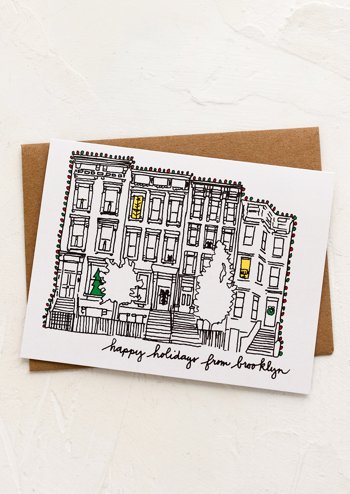 A card with drawing of brownstone and text reading "Happy holidays from Brooklyn".