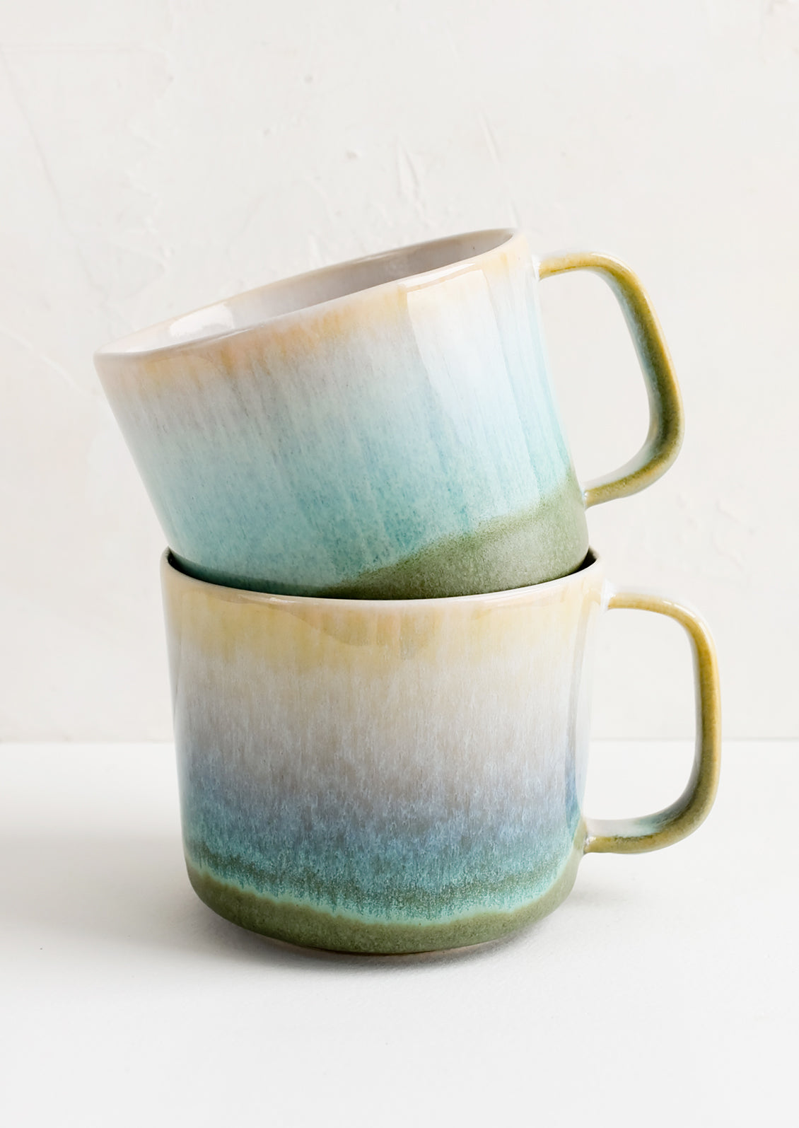 Two stacked ceramic mugs.