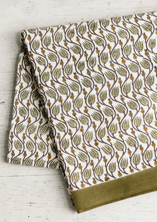 A botanical print tablecloth with olive green trim.