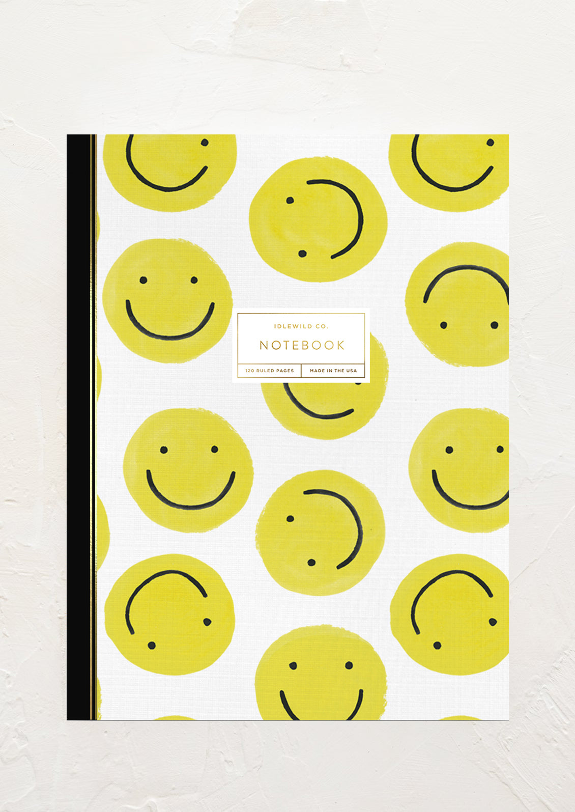 A notebook with yellow smiley face printed cover.