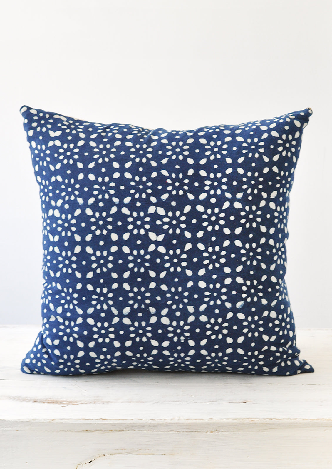 A square indigo and white block printed pillow.