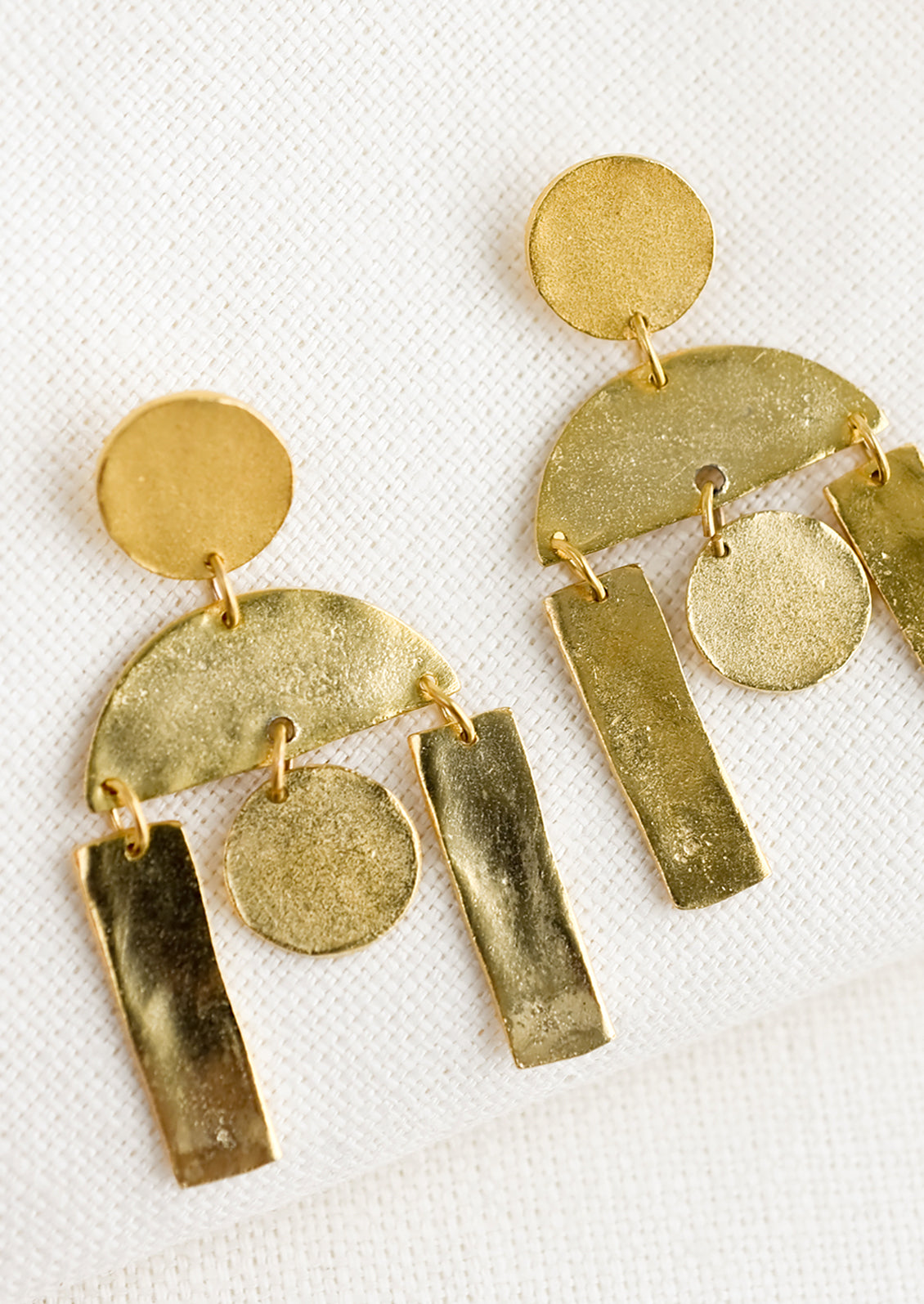 A pair of gold earrings with geometric chandelier design.