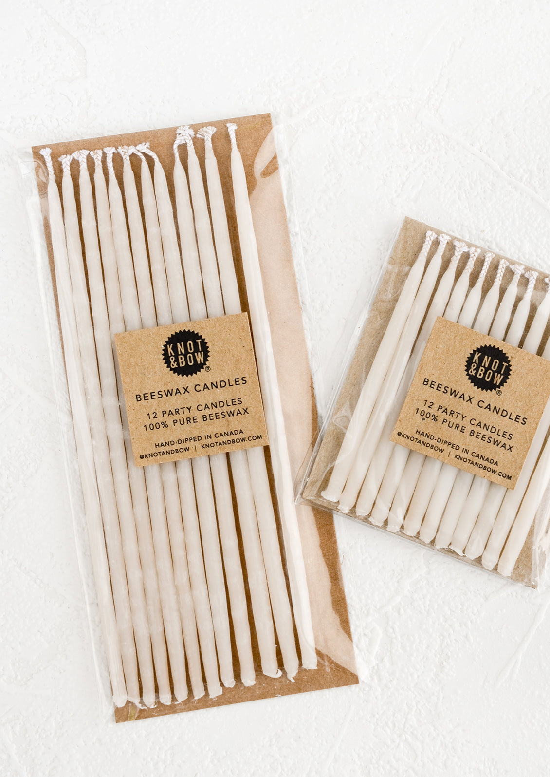 Two packages of ivory beeswax birthday candles in short and long lengths.