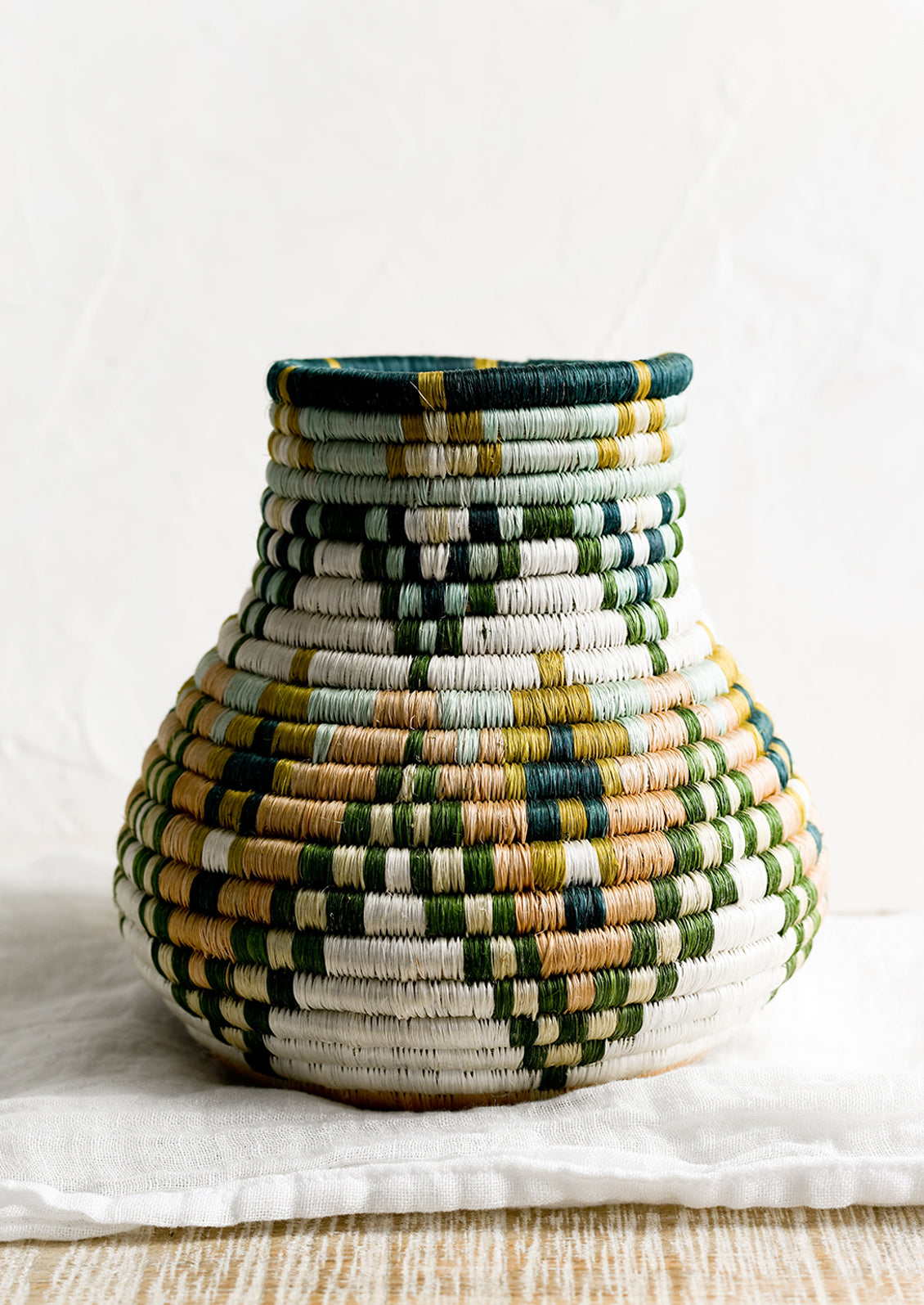 A sweetgrass woven vase with bulbous shape.