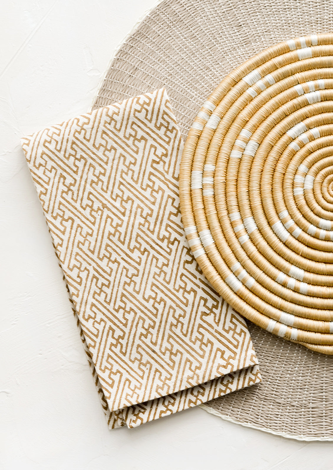 A flatlay arrangement of table linens in neutral hues.