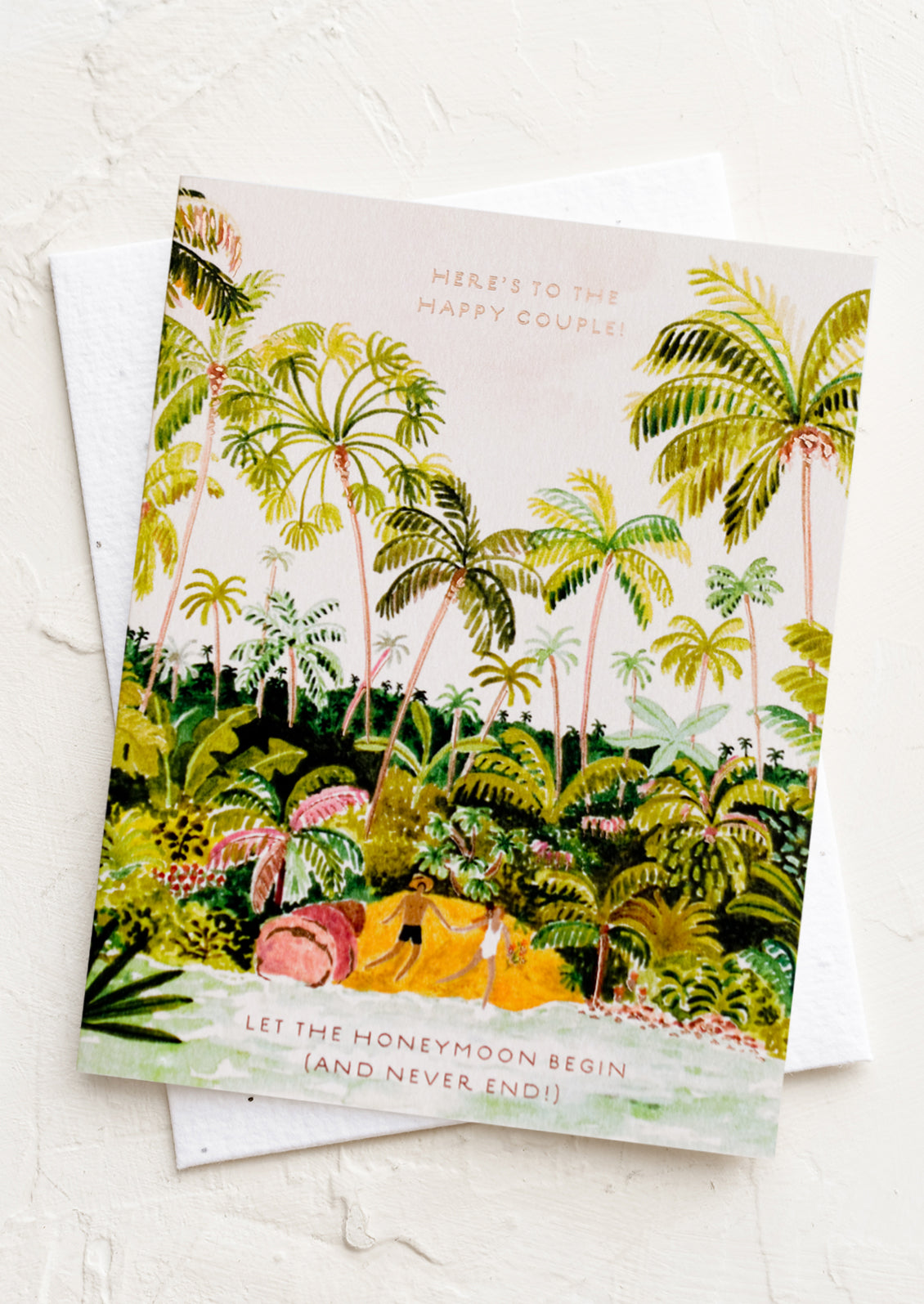 A card with illustration of couple in tropical area, text reads "Let the honeymoon begin (and never end)".