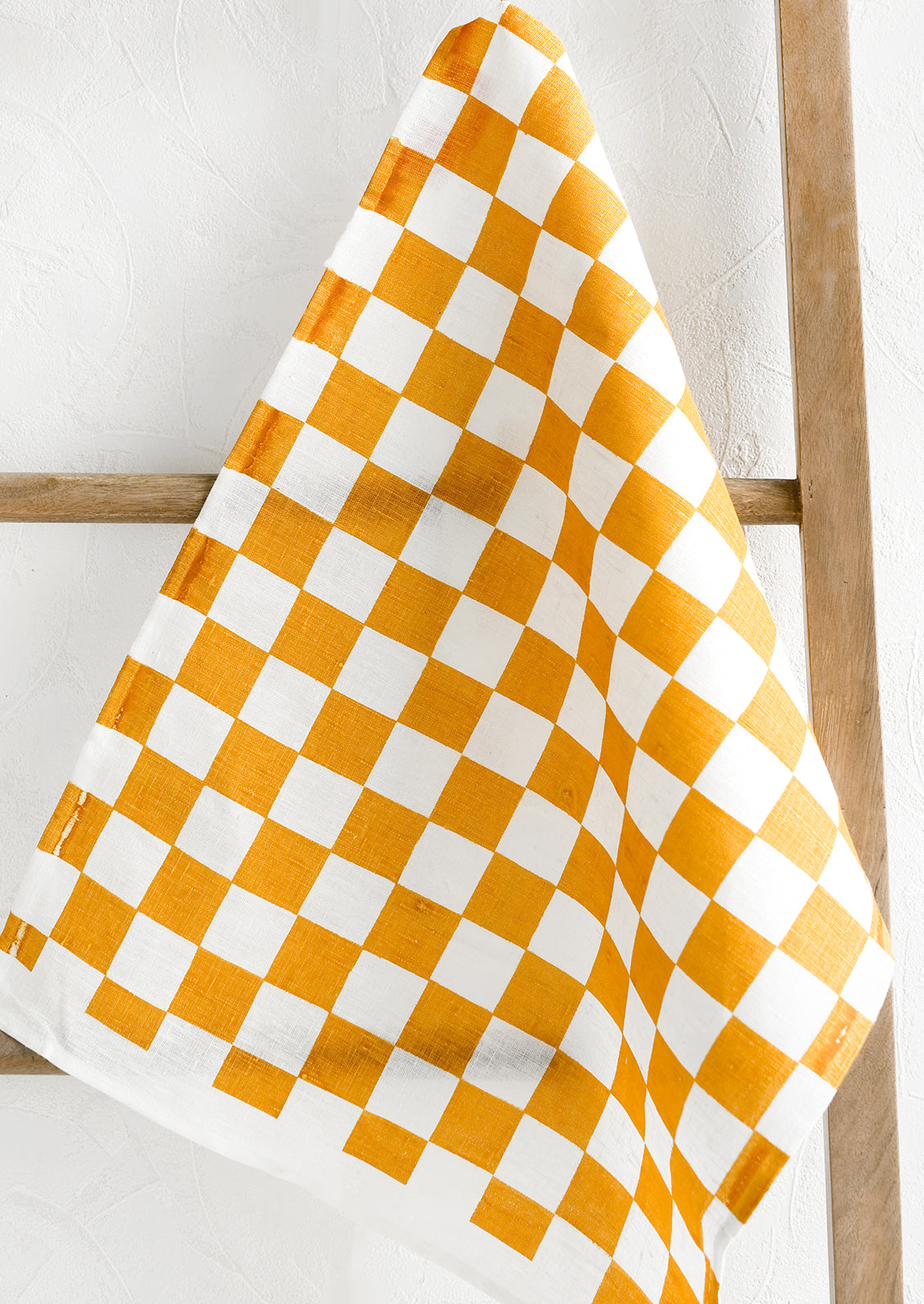 A checkered linen tea towel in orange and white.