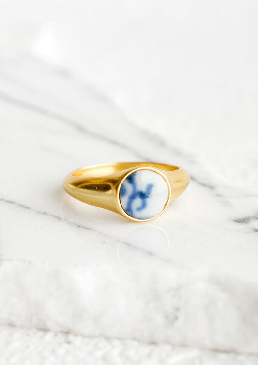 Gold signet ring with blue and white pottery signet.