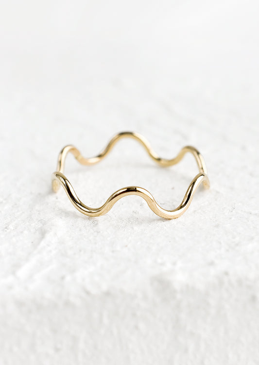 A thin gold ring in wavy shape.