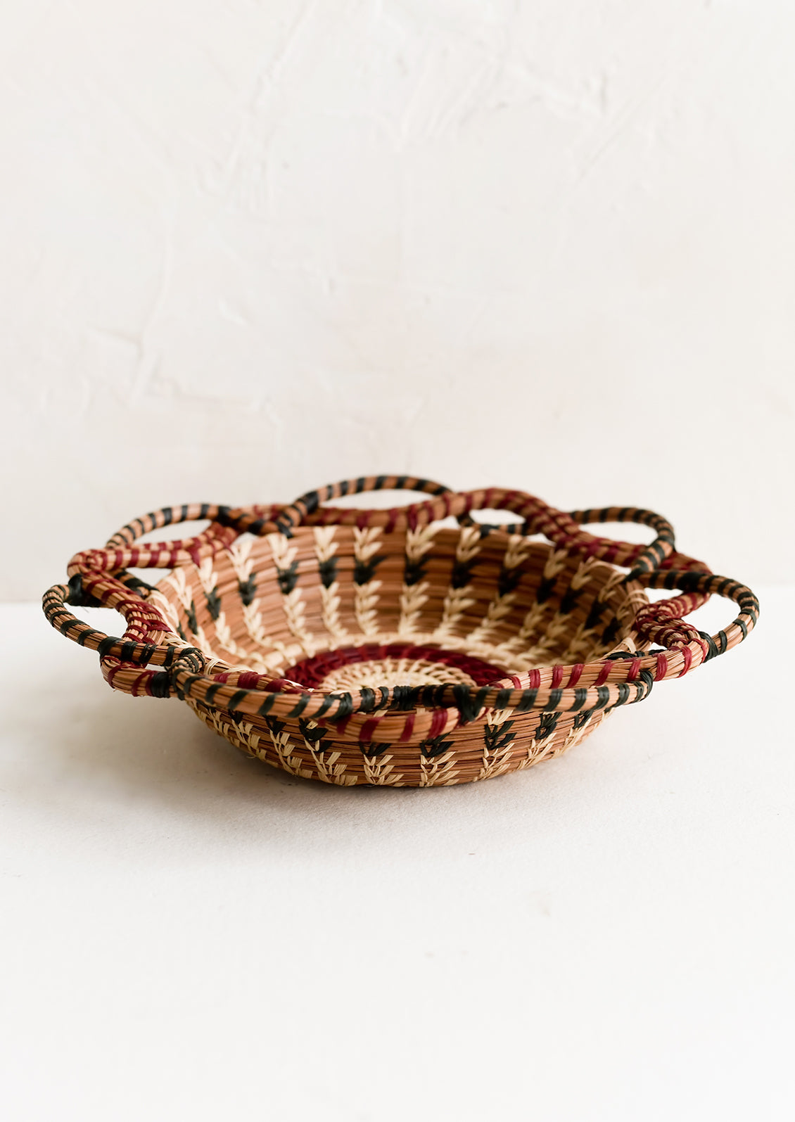 A woven basket with swirling, intertwined silhouette.