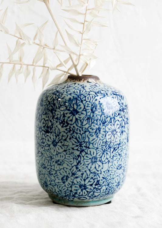 A vintage-look ceramic vase with indigo floral pattern.