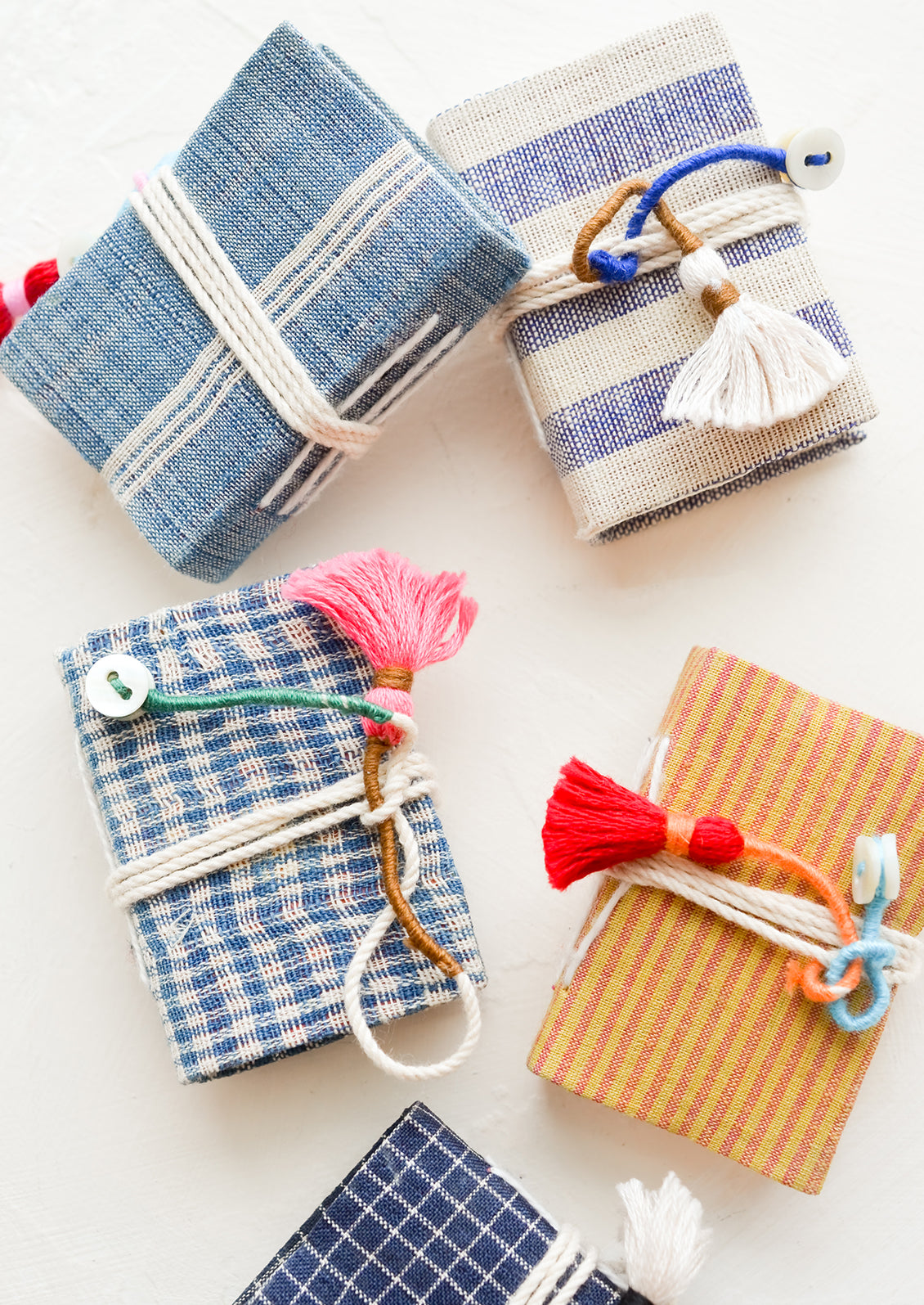 Tiny cotton cover journals in assorted fabrics.