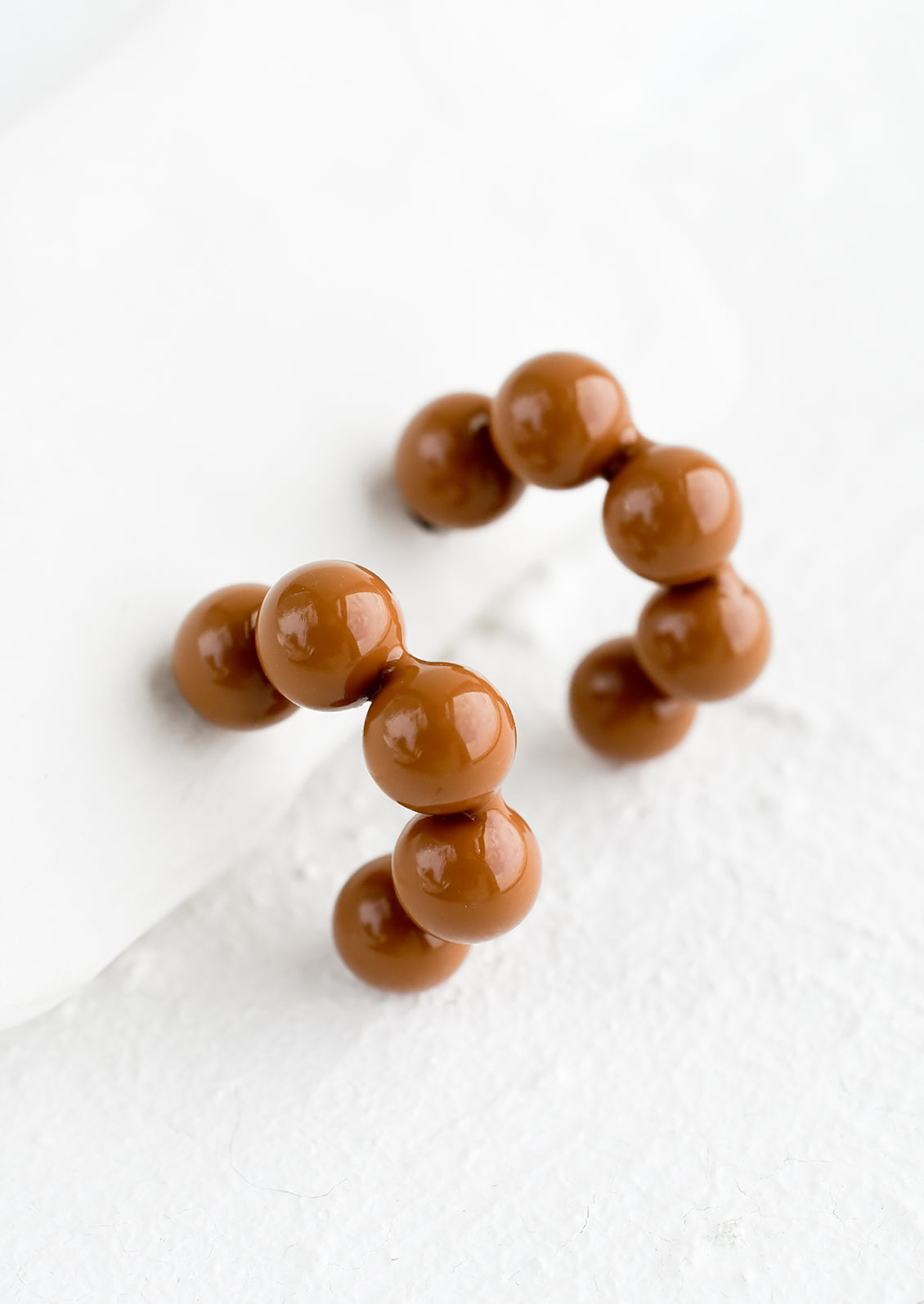 Glossy ball hoop earrings in chocolate color.