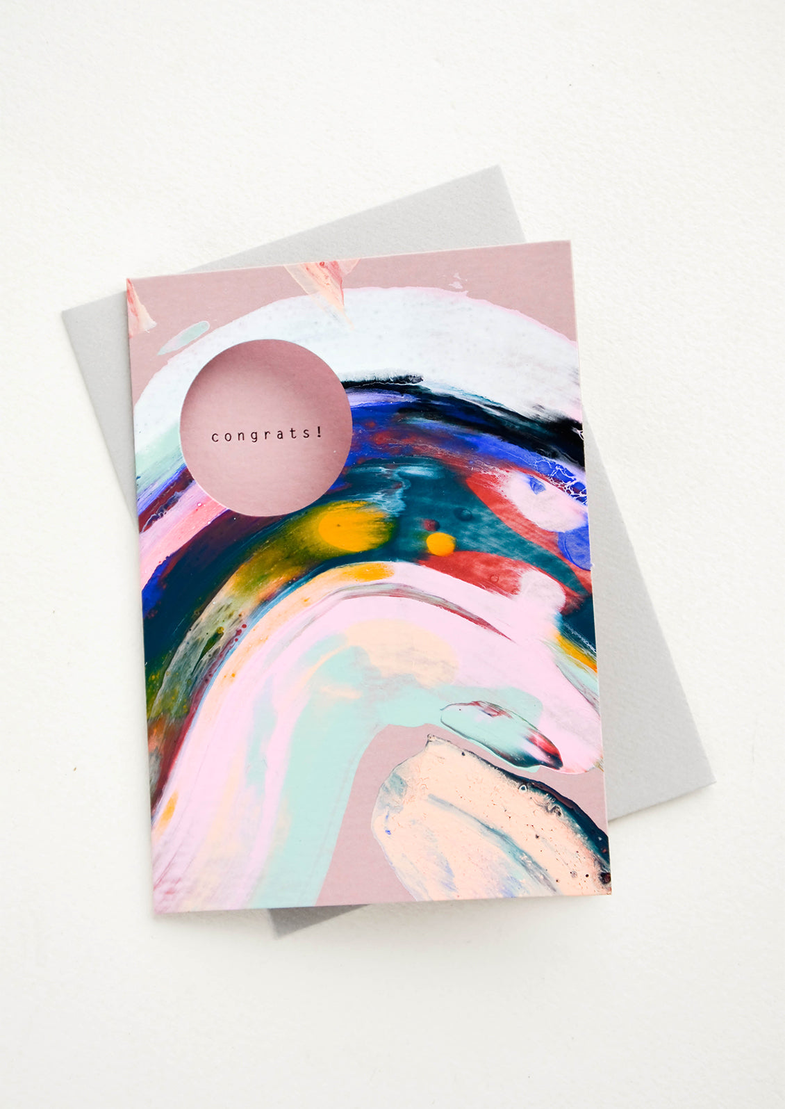 Greeting card with multicolor paint streak, circular cutout on front to reveal interior text