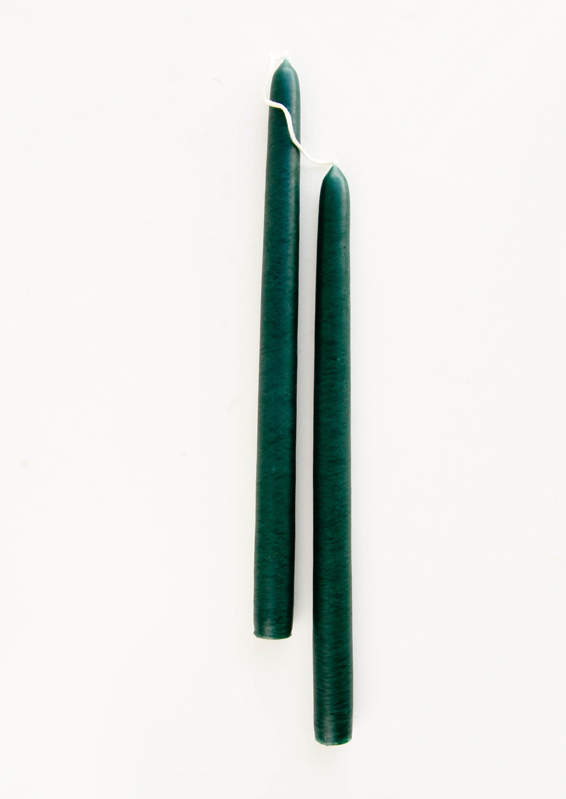 A pair of taper candles in emerald green.