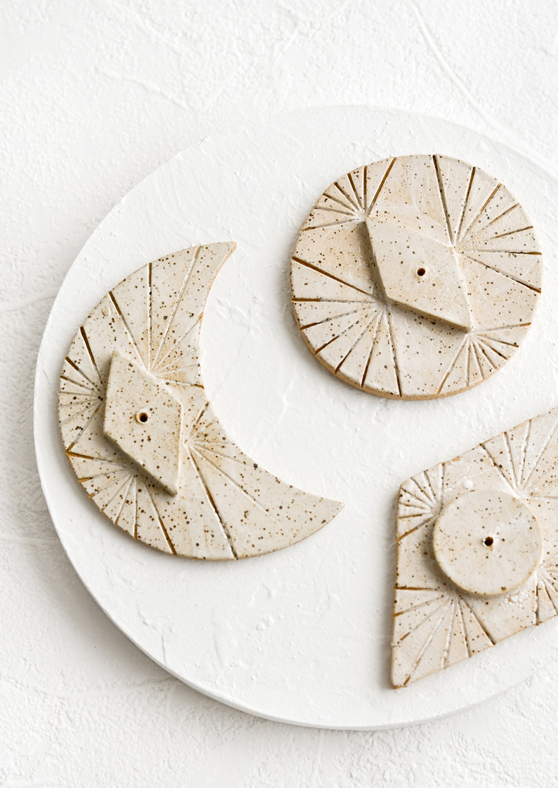 Ceramic incense stands in moon, circle and diamond shapes.