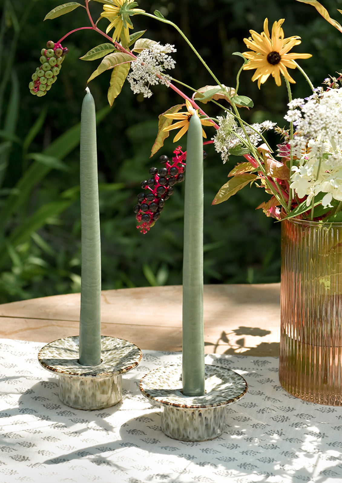 Short ceramic taper candle holders with saucer-like top in speckled reactive glaze