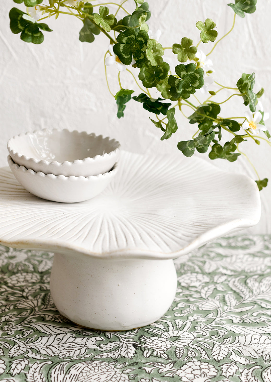 A white ceramic pedestal in the shape of a mushroom with flat top.