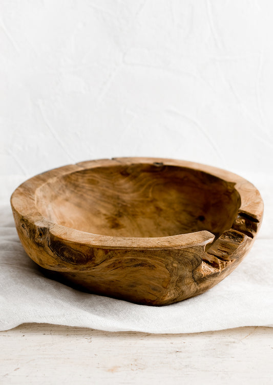 A teakwood bowl with natural knot cutout.